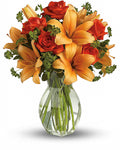 Bouquet of orange and red flowers in a clear glass vase 