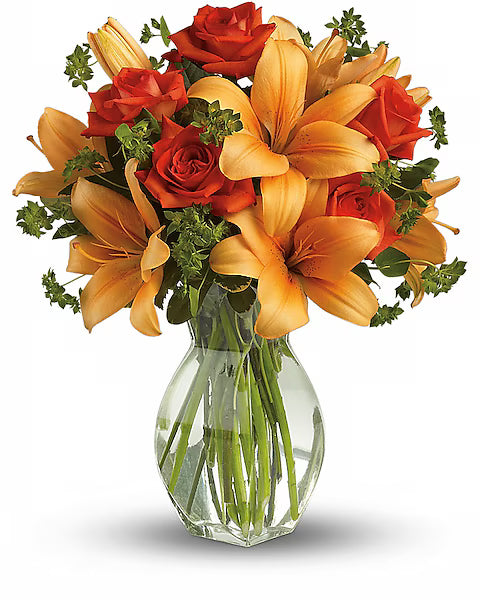 Bouquet of orange and red flowers in a clear glass vase 