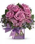 Bouquet of pink roses with a purple ribbon in a clear vase